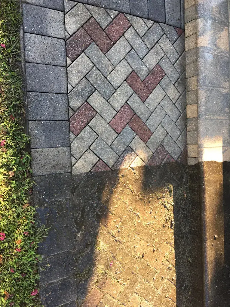 Herringbone paver walkway with the top cleaned and the bottom still covered in dirt