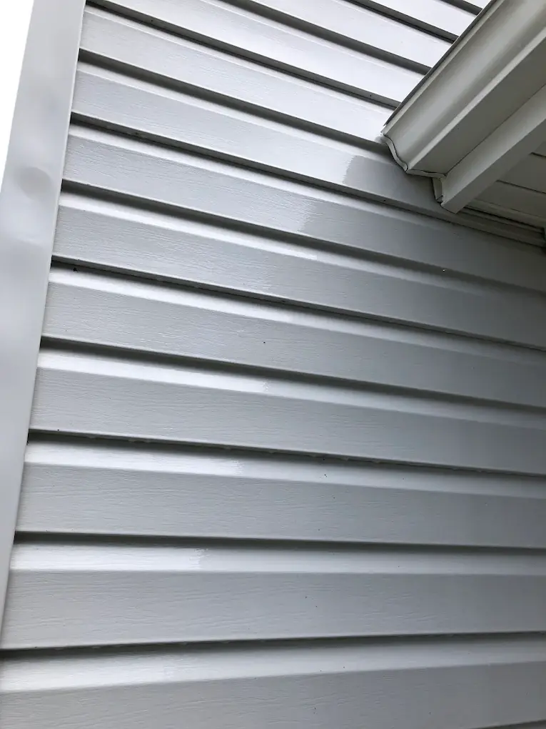 Close-up of clean, glossy white vinyl siding after house washing